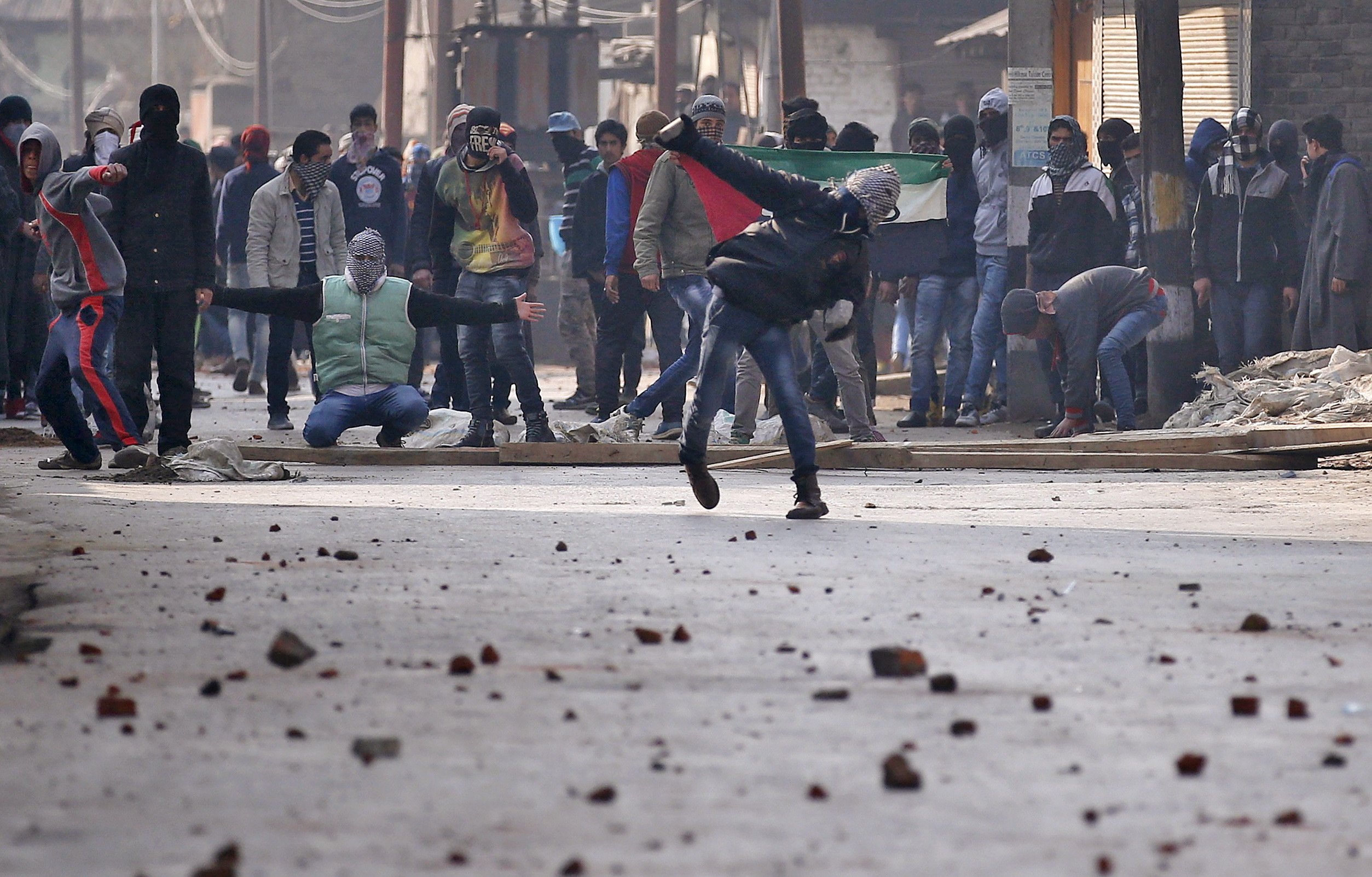 A Kashmiri protester throws a stone towards Indian police during a protest in Srinagar